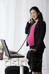 AsiaPix - Profile of pregnant businesswoman on phone