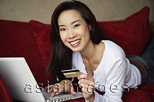 Asia Images Group - woman shopping online, on couch