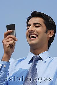 Asia Images Group - businessman reading message, laughing