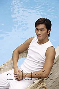 AsiaPix - Young man sitting poolside