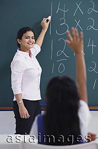 Asia Images Group - teacher at chalkboard, girl raises hand