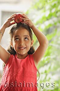 Asia Images Group - little girl holding apple on her head