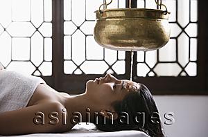 Asia Images Group - young woman having Ayurvedic spa treatment