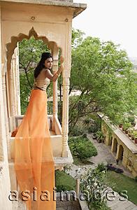 Asia Images Group - young woman in sari standing at terrace balcony