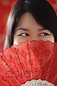 AsiaPix - Chinese woman looking over hand-held fan