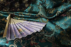AsiaPix - Detail of fan on top of jade green Chinese silk fabric