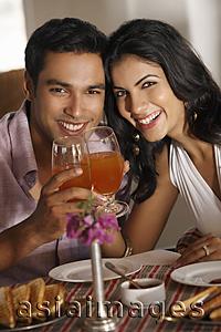 Asia Images Group - couple at restaurant, raising for a toast