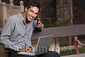 Asia Images Group - man on phone, with laptop computer