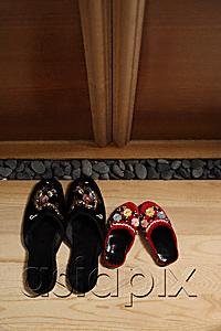 AsiaPix - top view of red and black oriental slippers at door front