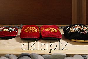 AsiaPix - front view of red and black oriental slippers at door front