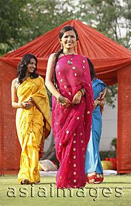 Asia Images Group - three women in saris in front of red tent