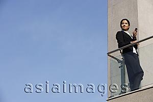 Asia Images Group - businesswoman with mobile phone, on balcony