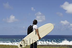 Asia Images Group - man holding surf board, facing sea