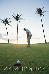 Asia Images Group - man playing golf during sunset