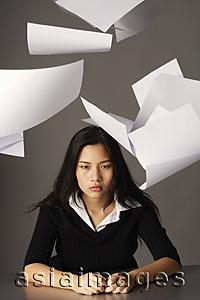 Asia Images Group - young lady sitting, paper falling