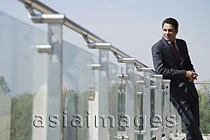 Asia Images Group - businessman leaning against railing on balcony