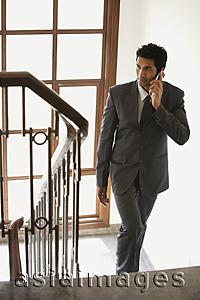 Asia Images Group - businessman on phone, walking up stairs