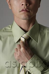 AsiaPix - crop portrait of man tightening tie