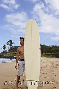 Asia Images Group - man standing on beach with surf board