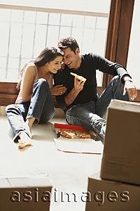 Asia Images Group - young couple having pizza on floor