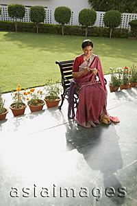 Asia Images Group - woman wearing a sari, knitting