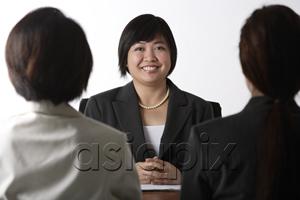 AsiaPix - business woman sitting at desk smiling
