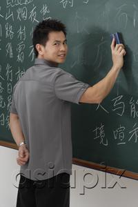 AsiaPix - man erasing Chinese characters on chalk board