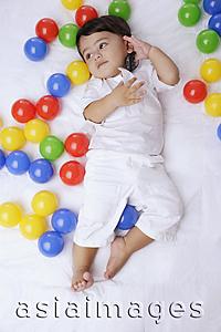 Asia Images Group - baby boy surrounded by balls, cell phone to ear