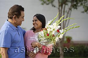 Asia Images Group - couple smiling at each other, woman with bouquet