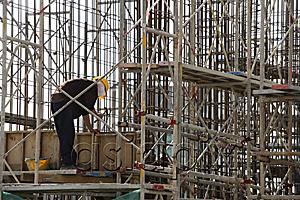 AsiaPix - Construction worker in building frame.