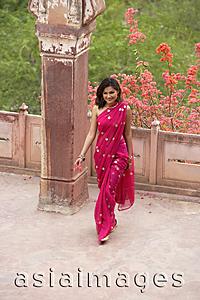 Asia Images Group - young woman in sari, walking away from balcony