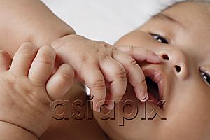 AsiaPix - Close up of hands on babies mouth.