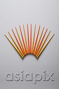 AsiaPix - Orange and yellow chopsticks in the shape of a fan.