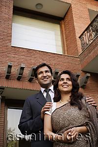 Asia Images Group - smiling couple, standing in front of home