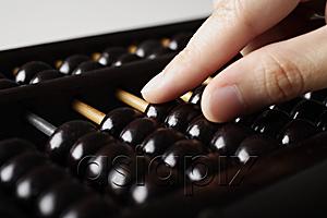 AsiaPix - close up of hand touching abacus