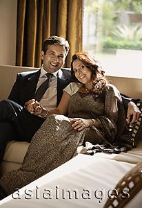 Asia Images Group - couple sitting on couch, holding hands