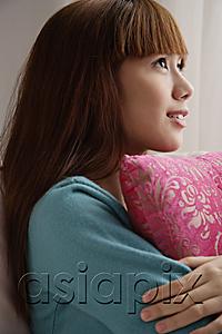 AsiaPix - Asian girl holding pink pillow, looking up