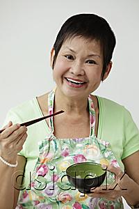AsiaPix - Mature Chinese woman holding chopsticks and bowl