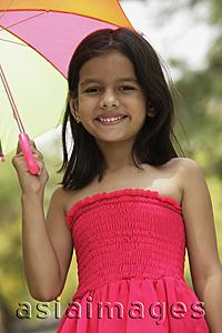 Asia Images Group - Little girl in pink dress standing under umbrella