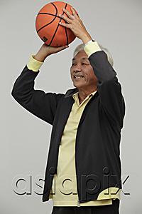 AsiaPix - Mature Chinese man playing basketball