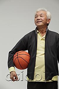 AsiaPix - Mature Chinese man holding a basketball