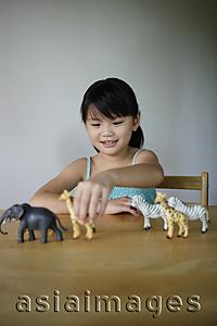 Asia Images Group - Little girl playing with plastic animals