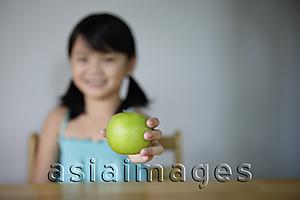 Asia Images Group - Little girl offering green apple