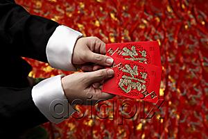 AsiaPix - Cropped shot of man holding lucky Hong Bao, red envelope