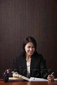AsiaPix - woman working and smiling at her desk