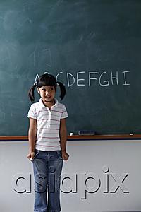 AsiaPix - young girl standing in front of the chalkboard smiling