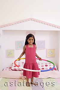 Asia Images Group - little girl on bed with hula hoop