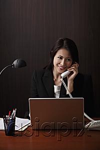 AsiaPix - Woman sitting at her desk talking on phone