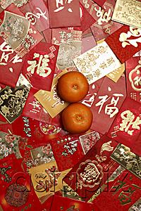 AsiaPix - Many different red envelopes, Hong Bao scattered on table with oranges.