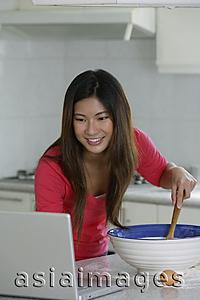 Asia Images Group - Woman reading recipe on laptop